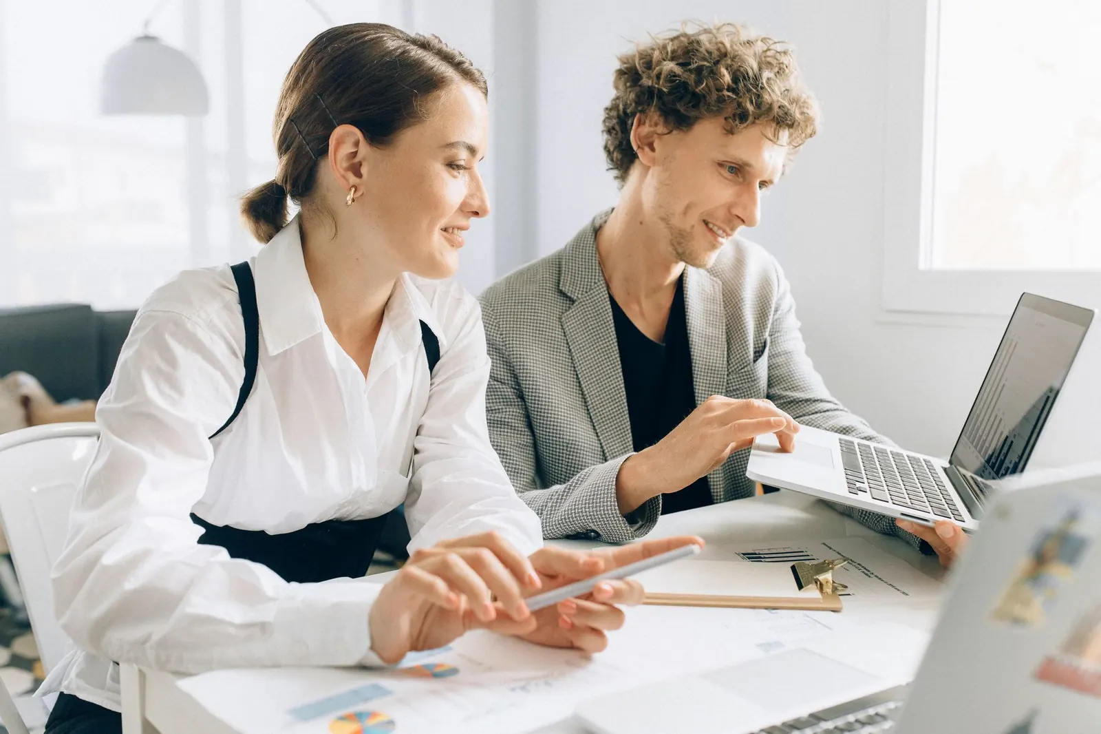Two colleagues working together on laptops